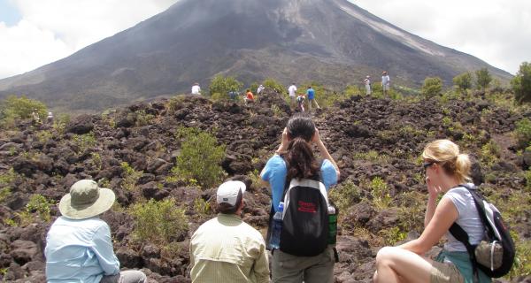 Arenal Volcano Tour Image: Travelers navigate rocky terrain and enjoy great views of Arenal Volcano.